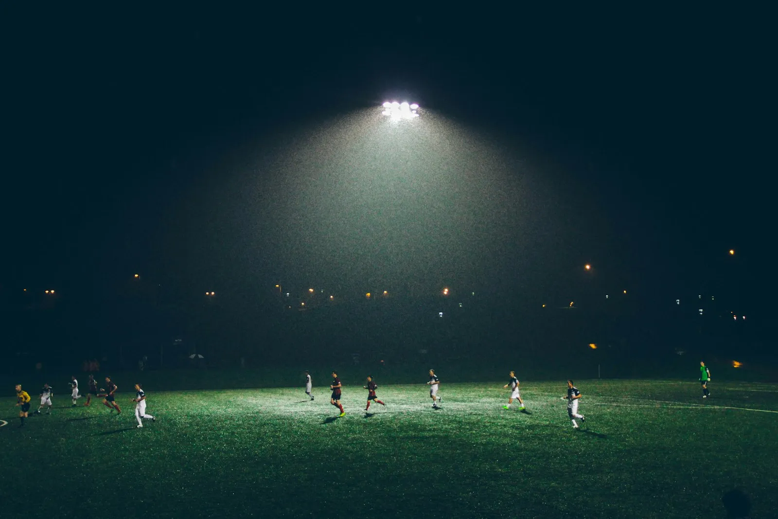 Young footballers training under floodlights on an East London pitch